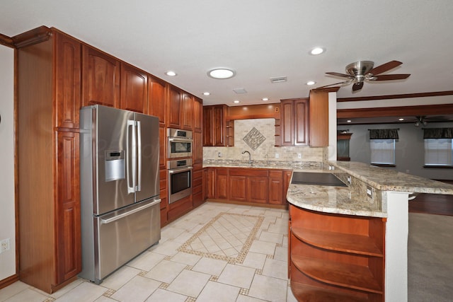 kitchen featuring tasteful backsplash, a kitchen breakfast bar, kitchen peninsula, stainless steel appliances, and light stone countertops