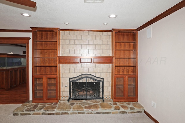 unfurnished living room featuring a fireplace, ornamental molding, a textured ceiling, and carpet flooring