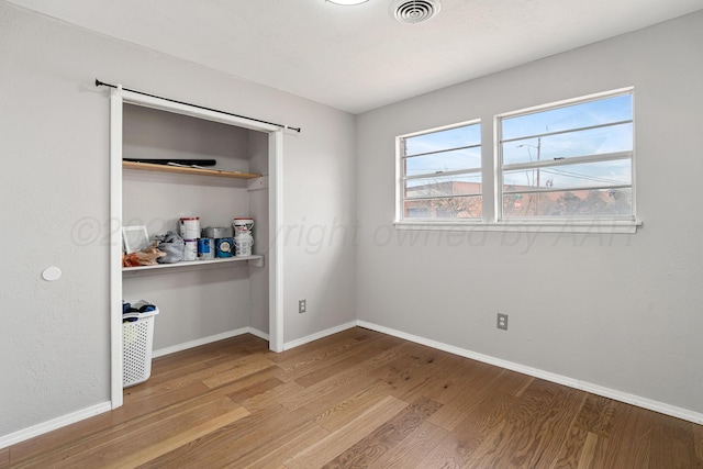 unfurnished bedroom with light hardwood / wood-style floors and a closet