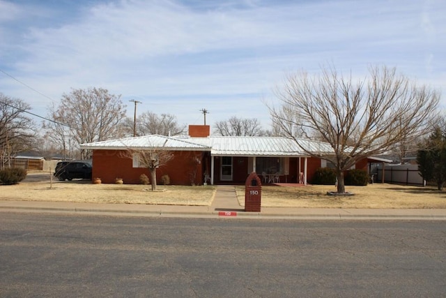 single story home featuring a chimney and fence