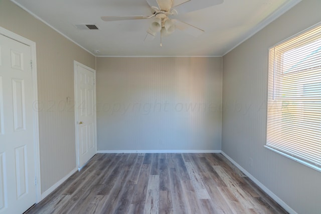 empty room featuring ceiling fan, wood-type flooring, and ornamental molding