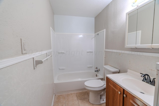 full bathroom with tile patterned floors, toilet, shower / washtub combination, vanity, and tile walls