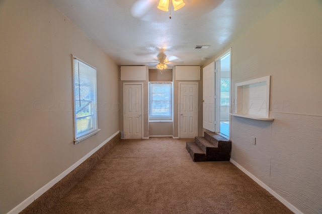 interior space with ceiling fan and carpet floors