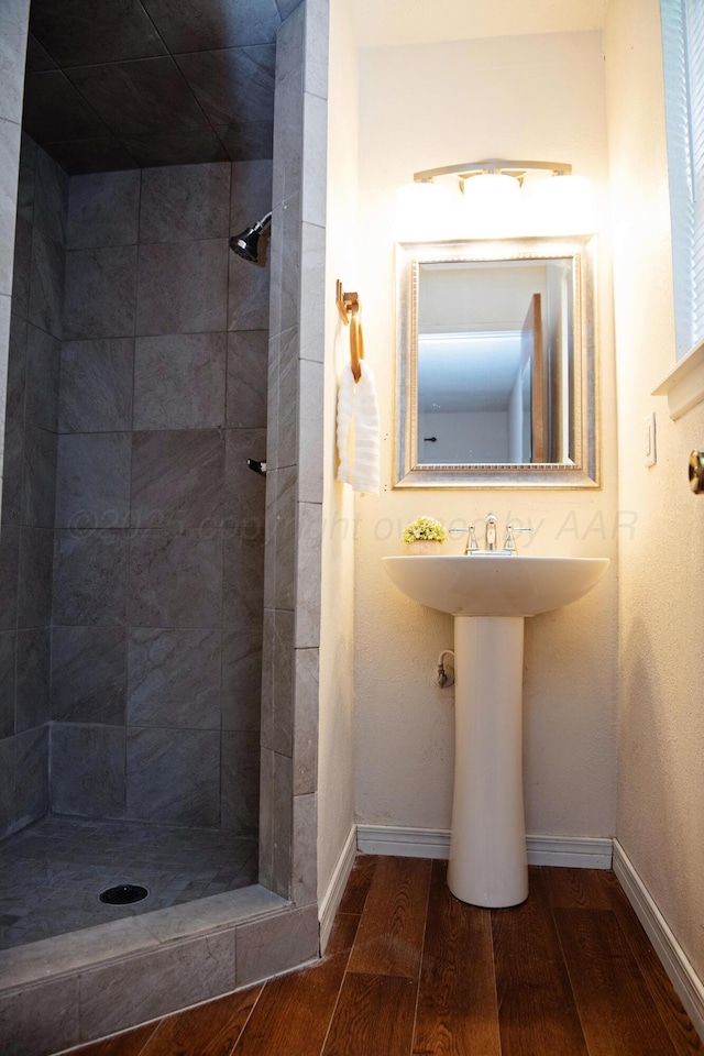 220 Hickory St, Hereford, TX 79045 - bathroom featuring wood finished floors and tiled shower