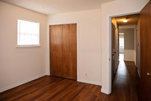 220 Hickory St, Hereford, TX 79045 - unfurnished bedroom featuring dark wood finished floors, a closet, and a textured ceiling