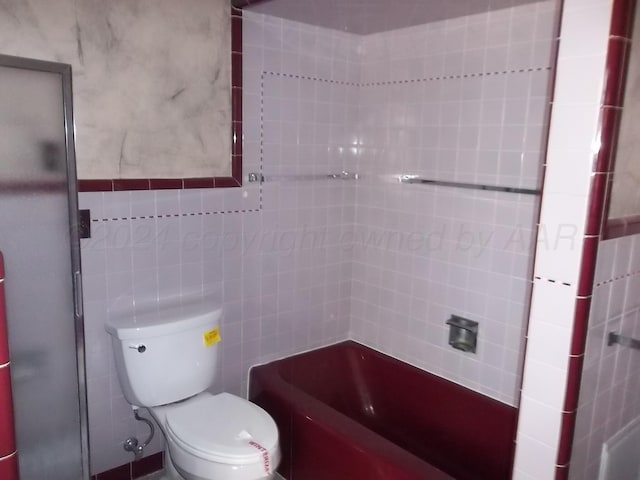 bathroom with walk in shower, toilet, and tile walls