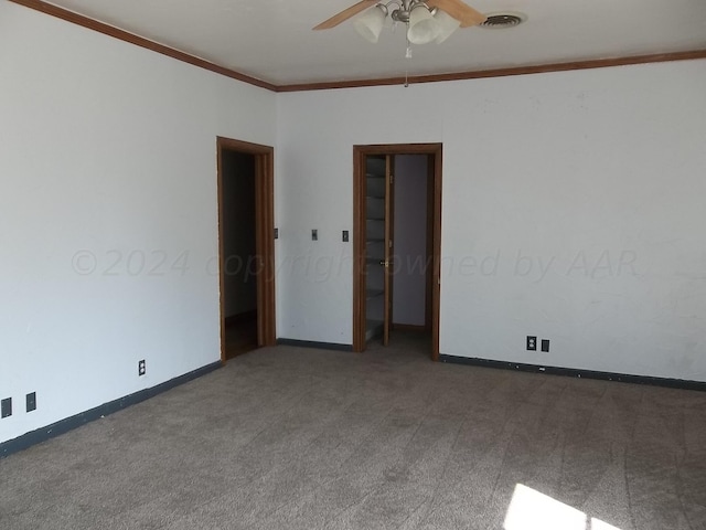 carpeted spare room with ceiling fan and ornamental molding