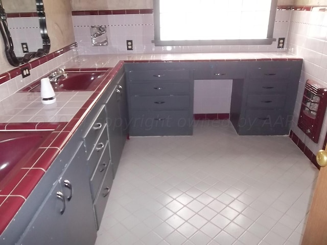 bathroom with tile patterned flooring, sink, and decorative backsplash