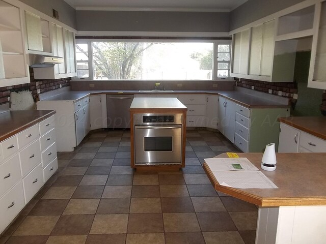 kitchen featuring a kitchen island, white cabinetry, appliances with stainless steel finishes, and plenty of natural light