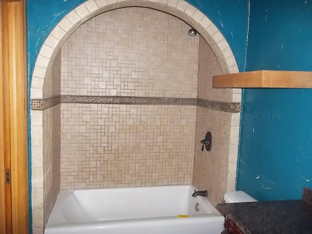 bathroom featuring toilet and tiled shower / bath combo