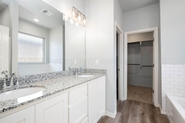 bathroom with vanity, a bath, and hardwood / wood-style floors