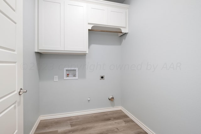 clothes washing area featuring gas dryer hookup, cabinets, wood-type flooring, washer hookup, and hookup for an electric dryer