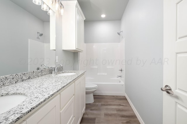 full bathroom featuring wood-type flooring, bathtub / shower combination, vanity, and toilet