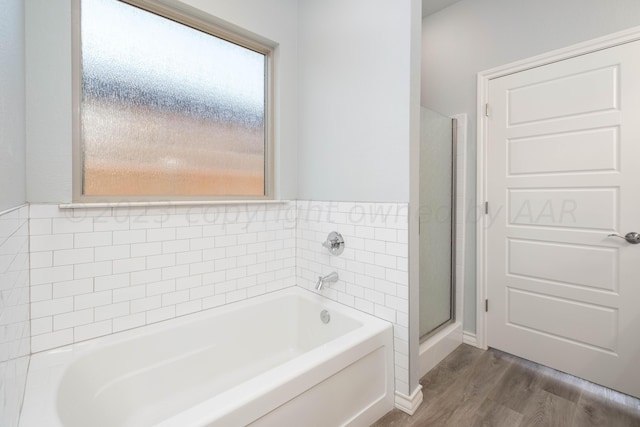 bathroom with hardwood / wood-style floors and independent shower and bath