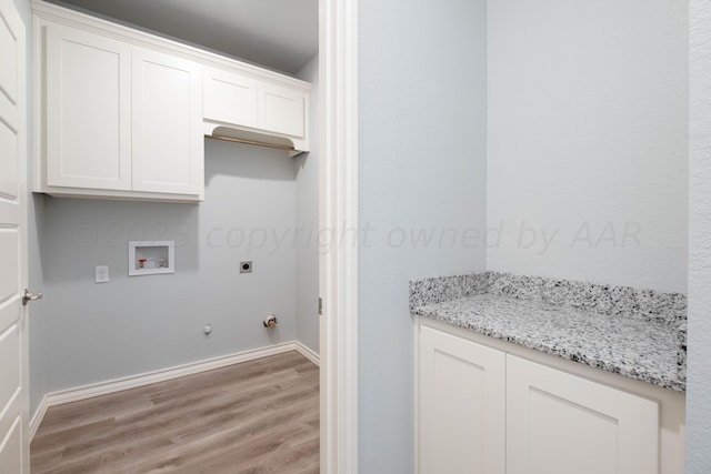 laundry room featuring gas dryer hookup, cabinets, washer hookup, light hardwood / wood-style floors, and electric dryer hookup