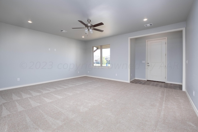 carpeted spare room featuring ceiling fan