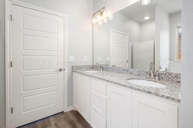 bathroom featuring wood-type flooring, an enclosed shower, and vanity