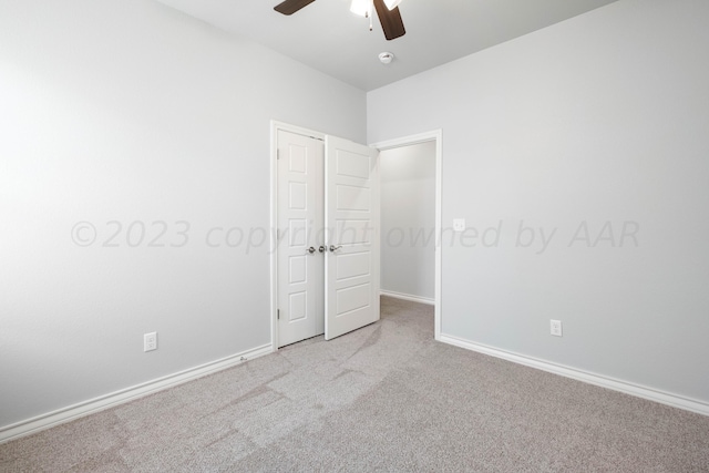 spare room featuring light colored carpet and ceiling fan