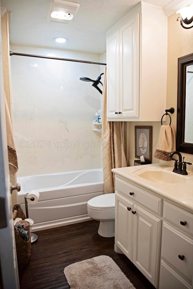 full bathroom featuring vanity, bathtub / shower combination, toilet, a textured ceiling, and wood-type flooring