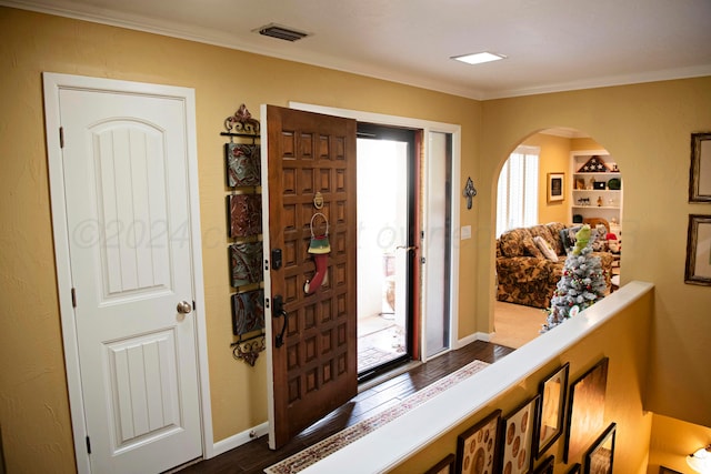 entrance foyer with dark hardwood / wood-style floors and ornamental molding