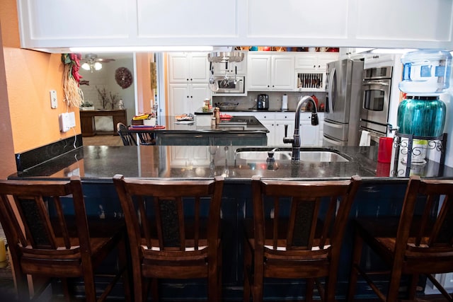 kitchen featuring white cabinetry, sink, a breakfast bar area, and stainless steel appliances