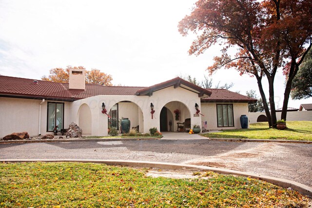 mediterranean / spanish-style home with a front lawn