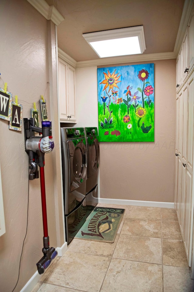 washroom featuring washer and dryer, cabinets, light tile patterned floors, and crown molding