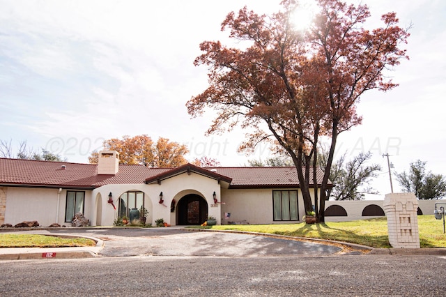 mediterranean / spanish-style house featuring a front yard