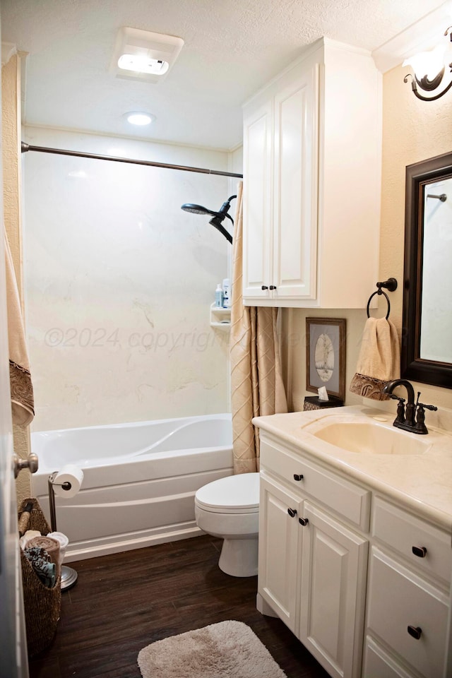 full bathroom featuring vanity, a textured ceiling, shower / bathtub combination with curtain, hardwood / wood-style floors, and toilet