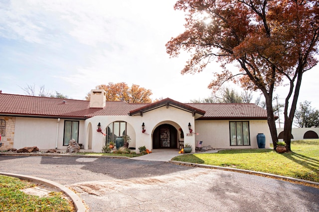 mediterranean / spanish home with a front yard