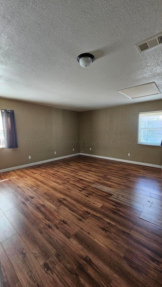 1300 Patton Cir, Borger, TX 79007 - empty room with dark wood-type flooring and a textured ceiling