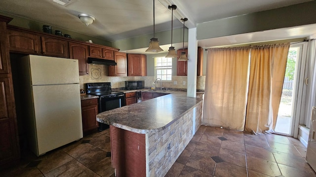 1300 Patton Cir, Borger, TX 79007 - kitchen with black appliances, under cabinet range hood, a peninsula, decorative backsplash, and decorative light fixtures
