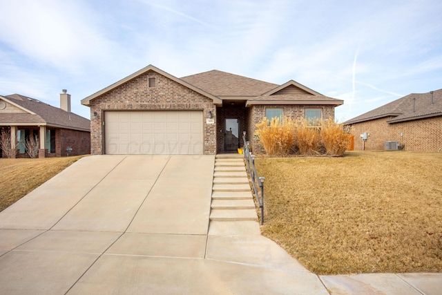 single story home with a front lawn, central AC unit, and a garage