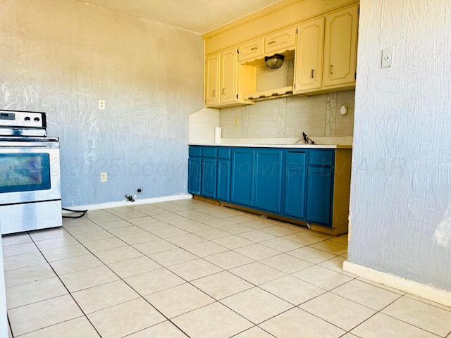 2400 SW 4th Ave, Amarillo, TX 79106 - kitchen featuring baseboards, light tile patterned floors, light countertops, blue cabinetry, and stainless steel electric stove