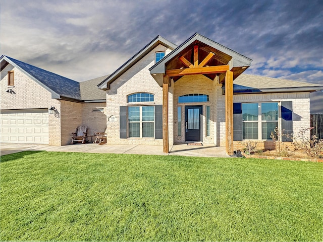 view of front of home with a garage, a patio, and a front yard