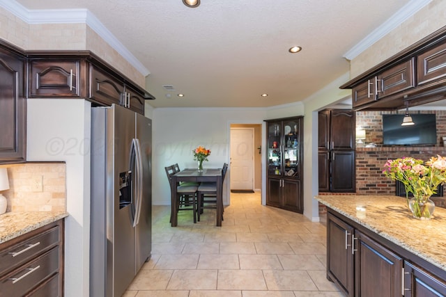 kitchen featuring stainless steel refrigerator with ice dispenser, dark brown cabinetry, baseboards, crown molding, and recessed lighting