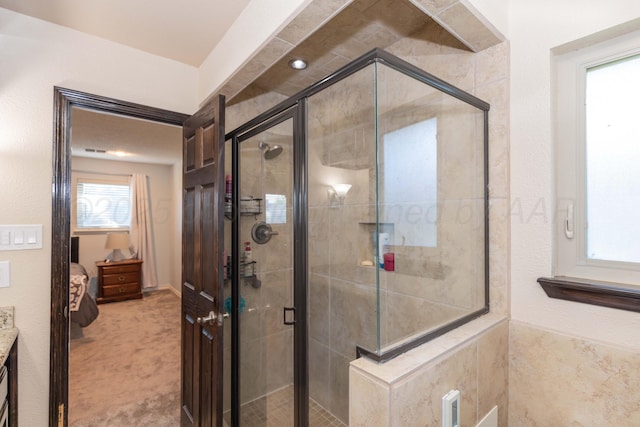ensuite bathroom featuring a stall shower and vanity