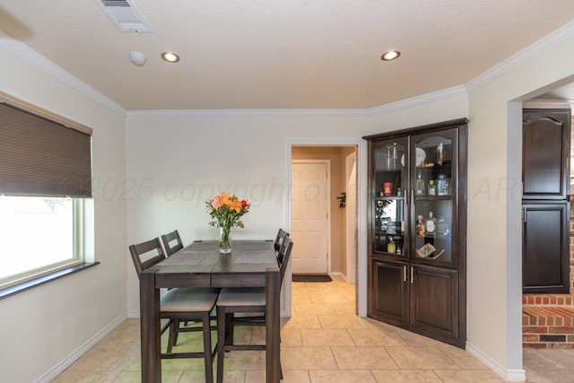 dining space with crown molding, baseboards, and recessed lighting
