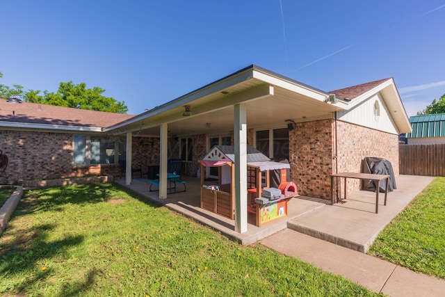 back of property with brick siding and a patio