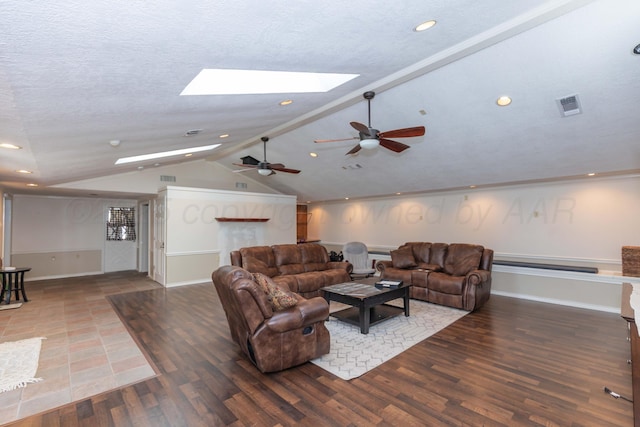 living area with a skylight, lofted ceiling, a ceiling fan, wood finished floors, and recessed lighting