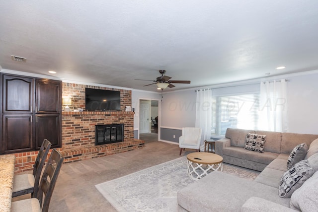 carpeted living area with ceiling fan, a brick fireplace, ornamental molding, recessed lighting, and baseboards