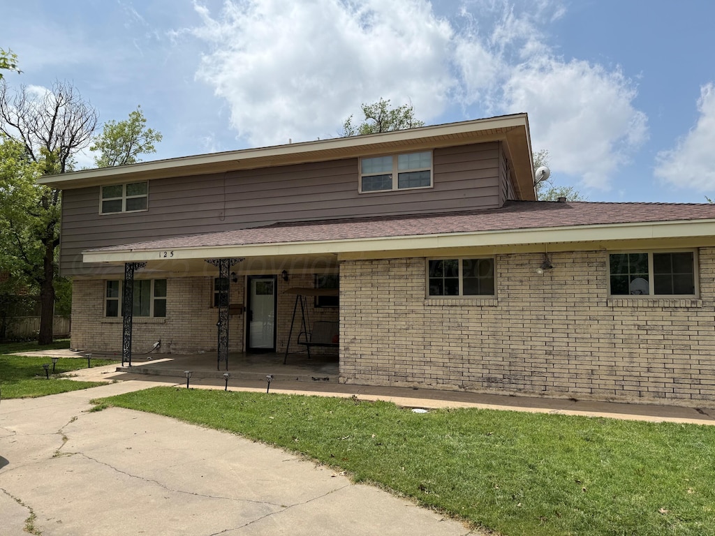 125 Mulberry Dr, Dumas, TX 79029 - back of house featuring brick siding and a lawn