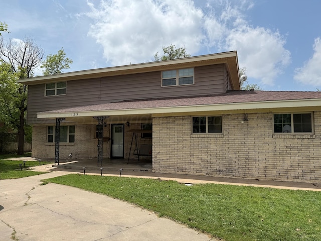 125 Mulberry Dr, Dumas, TX 79029 - back of house featuring brick siding and a lawn
