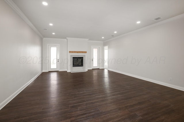 unfurnished living room with dark hardwood / wood-style flooring, a tiled fireplace, and crown molding