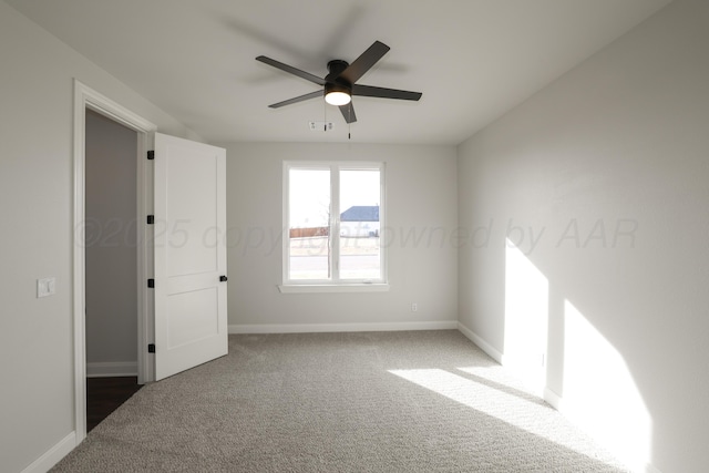 carpeted spare room featuring ceiling fan