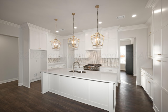 kitchen featuring white cabinetry, ornamental molding, decorative light fixtures, and sink