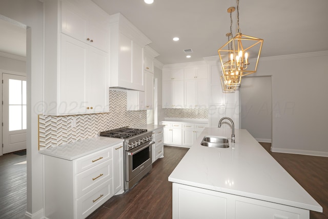 kitchen featuring high end stainless steel range oven, white cabinetry, sink, and a center island with sink