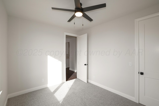 unfurnished bedroom featuring dark carpet and ceiling fan