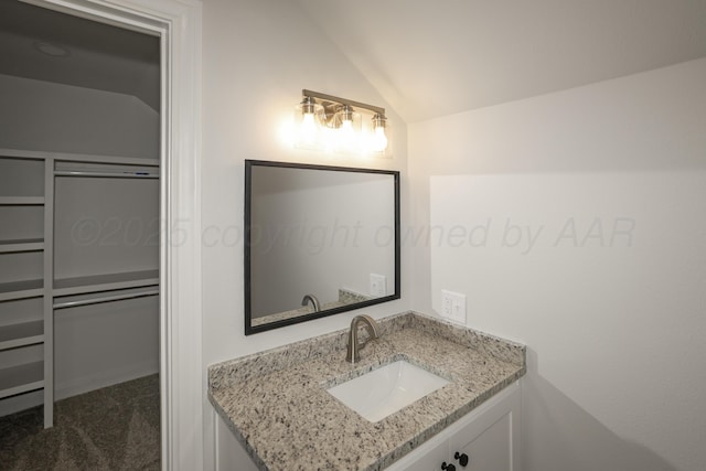 bathroom featuring lofted ceiling and vanity