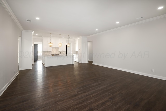 unfurnished living room featuring crown molding and dark hardwood / wood-style flooring